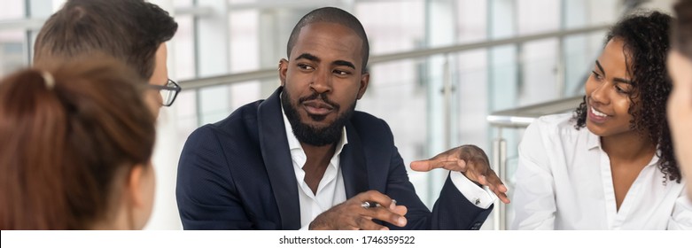 Multi ethnic employees involved in corporate training in boardroom, african team leader company boss business coach leading seminar activity concept. Horizontal photo banner for website header design