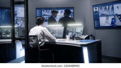 Multi ethnic employees talk and control CCTV cameras with AI face scanning in surveillance center together. Multiple big screens on the wall showing security cameras footage. Concept of social safety. - Shutterstock ID 2304488981
