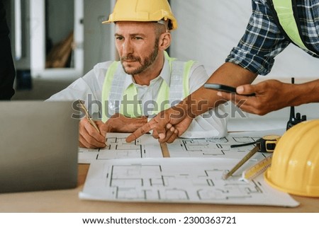 multi ethnic engineer brainstorming and measuring for cost estimating on paperworks and floor plan drawings about design architectural and engineering for houses and buildings.