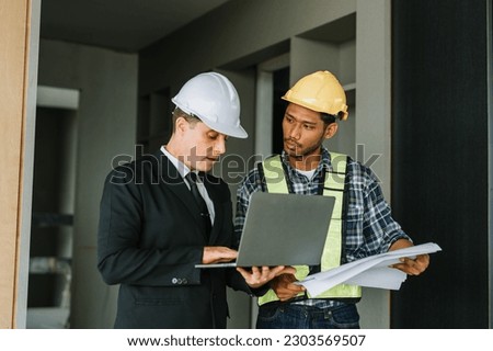 multi ethnic engineer brainstorming and measuring for cost estimating on blueprint and floor plan drawings about design architectural and engineering for houses and buildings.