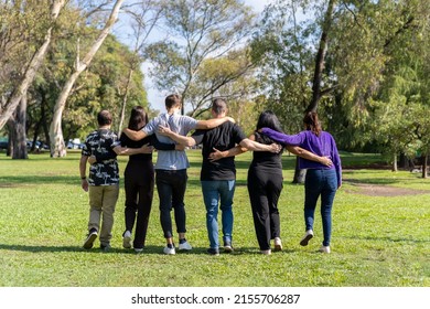 Multi Ethnic Family Group Walking Arm In Arm In A Park. Family, Group, Teamwork, Friendship Concept