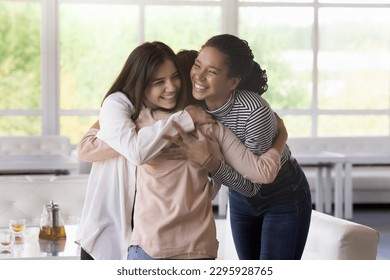 Multi ethnic girls, best friends greet, meet each other in lounge cafe, hugging with love and affection, express warmth, enjoy their strong friendship gathered in public place. Communication, congrats - Powered by Shutterstock