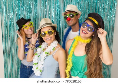 Multi ethnic group of Brazilian friends. Costumed revelers are happy and celebrating the Carnival with much celebration. Everyone is wearing sunglasses and a hat. Lifestyle.