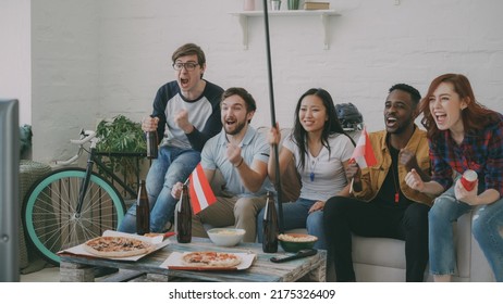 Multi Ethnic Group Of Friends Sports Fans With Austrian National Flags Watching Hockey Championship On TV Together Cheering Up Their Favourite Team At Home Indoors