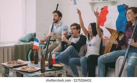 Multi Ethnic Group Of Friends Sports Fans With French National Flags Watching Hockey Championship On TV Together Cheering Up Their Favourite Team At Home Indoors