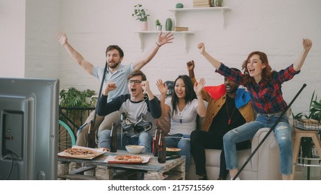 Multi Ethnic Group Of Friends Sports Fans With French National Flags Watching Hockey Championship On TV Together Cheering Up Their Favourite Team At Home Indoors