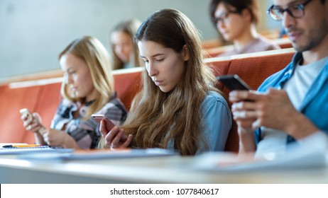 Multi Ethnic Group of Students Using Smartphones During the Lecture. Young People Using Social Media while Studying in the University.