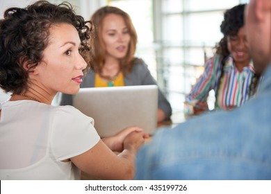 Multi Ethnic Group Of Succesful Creative Business People Using A Laptop During Candid Meeting