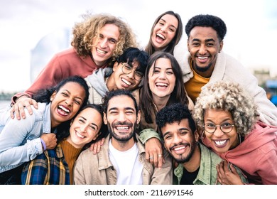 Multi ethnic guys and girls taking selfie outdoors with backlight - Happy life style friendship concept on young multicultural people having fun day together in Barcelona - Bright vivid filter