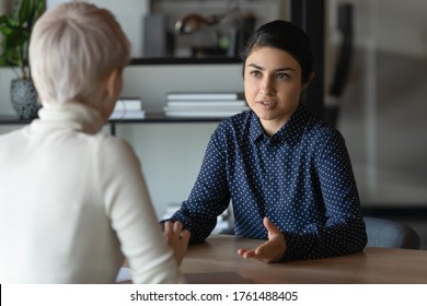 Multi ethnic indian and caucasian diverse young businesswomen sitting in front of each other in office during business meeting. HR manager and vacancy candidate talk, job interview and hiring concept - Shutterstock ID 1761488405