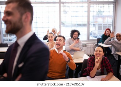 Multi Ethnic Students Making Fun Of Lecturer In A Classroom Behind His Back. Smart Young People Study At A College.