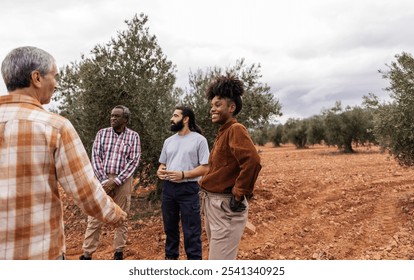 Multi ethnic team of farmers discussing during olive collection in an olive grove plantation, sharing knowledge and expertise for a successful harvest - Powered by Shutterstock