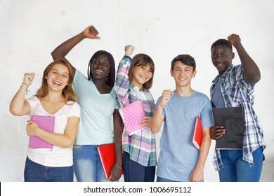 Multi Ethnic Teenagers Smiling At School, Raising Arms, Isolated On White Background.