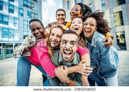 Multi ethnic young people smiling together at camera outdoors - Happy group of friends having fun hanging out in downtown street - University students standing together in college campus 