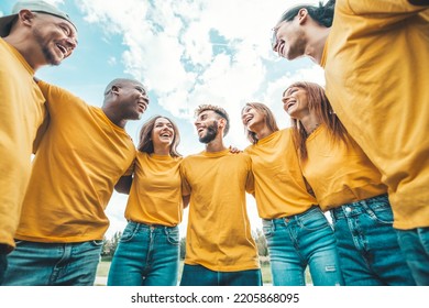 Multi ethnic young people team hugging together outside - International community of students support and help each other - Friendship, team building and diversity concept - Shutterstock ID 2205868095