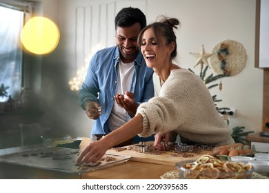 Multi ethnicity couple making a gingerbreads in Christmas time  - Powered by Shutterstock