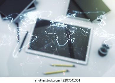 Multi exposure of abstract creative digital world map and digital tablet on background, top view, research and analytics concept