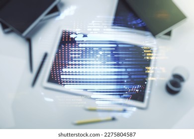 Multi exposure of abstract software development hologram with world map and digital tablet on background, top view, global research and analytics concept