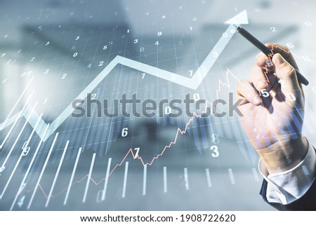 Multi exposure of analyst hand with pen working with virtual abstract financial graph and upward arrow on blurred office background, financial and trading concept