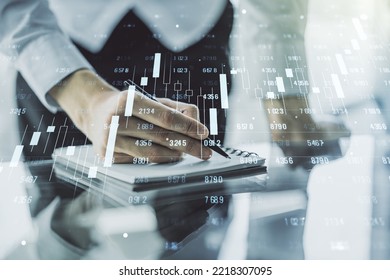 Multi exposure of creative statistics data hologram with man hand writing in notebook on background, stats and analytics concept