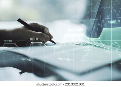 Multi exposure of creative statistics data hologram with hand writing in notebook on background with laptop, stats and analytics concept