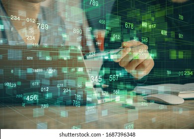 Multi exposure of data internet theme hologram with man working on computer on background. Concept of innovation.