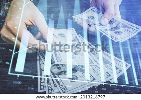 Multi exposure of financial graph drawing hologram and USA dollars bills and man hands. Analysis concept.