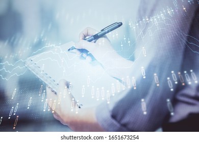 Multi exposure of hands making notes with forex chart huds. Stock market concept. - Powered by Shutterstock - Get 15% off with code: PIKWIZARD15