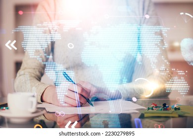 Multi exposure of hands making notes with world map hologram and data theme icons. Concept of global computer data.
