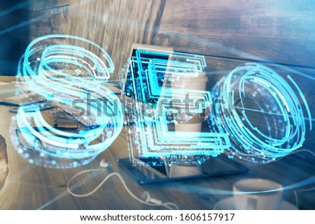 Multi exposure of table with computer and seo drawing hologram. Search optimization concept.