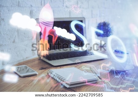 Multi exposure of table with computer and seo drawing hologram. Search optimization concept.