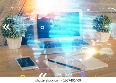 Multi exposure of table with computer and world map hologram. International data network concept.