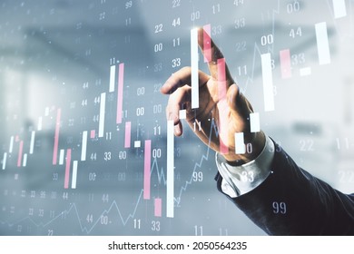 Multi exposure of trader hand clicks on virtual abstract financial graph interface on blurred office background, financial and trading concept