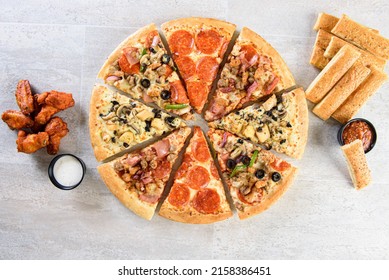 Multi Flavor Pizza Pie With Chicken Wings And Bread Sticks