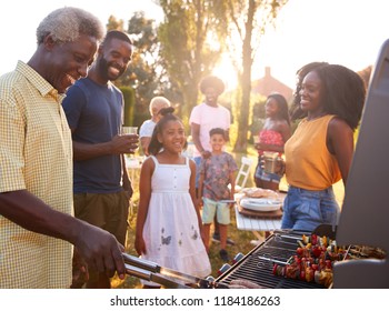 Multi generation black family barbecue, grandad grilling - Powered by Shutterstock