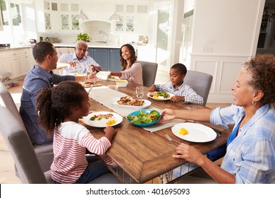 Multi Generation Black Family Serving A Meal In The Kitchen