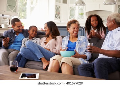 Multi Generation Black Family Talking Together While Watching TV