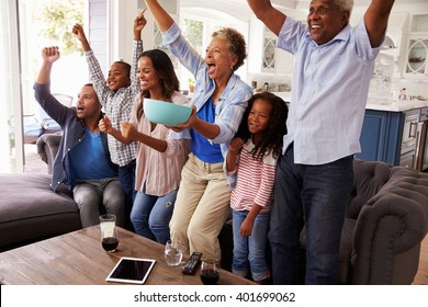 Multi Generation Black Family Watching Sport On TV Celebrate