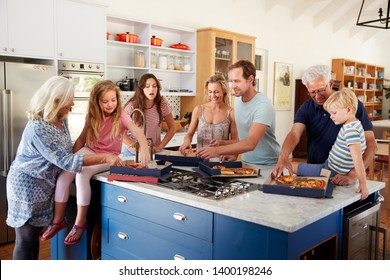 Multi Generation Family Around Kitchen Island Eating Takeaway Pizza Together