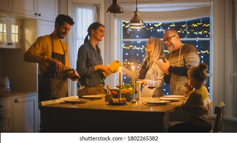 Multi Generation Family Of Celebrating Together, Gathering Around The Table With Delicious Dinner Meal. Young Mother Takes Dish Out Of Oven Grandparents Admire How Delicious Casserole Looks