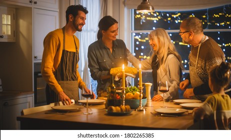 Multi Generation Family Of Celebrating Together, Gathering Around The Table With Delicious Dinner Meal. Young Mother Takes Dish Out Of Oven Grandparents Admire How Delicious Casserole Looks