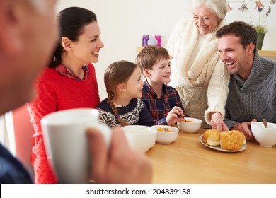 Multi Generation Family Eating Lunch At Kitchen Table