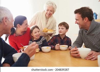 Multi Generation Family Eating Lunch At Kitchen Table