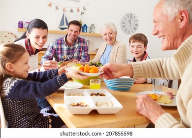 Multi Generation Family Eating Lunch At Kitchen Table