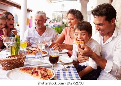Multi Generation Family Eating Meal At Outdoor Restaurant
