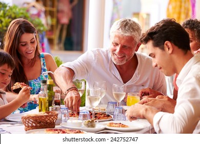 Multi Generation Family Eating Meal At Outdoor Restaurant