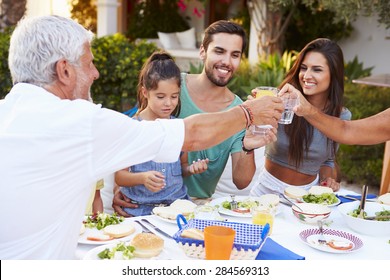 Multi Generation Family Eating Meal At Outdoors Together