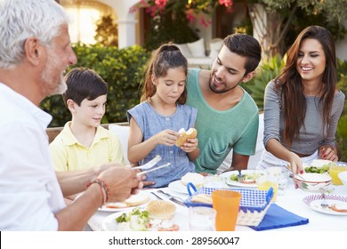 Multi Generation Family Eating Meal At Outdoors Together