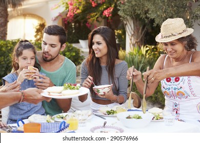 Multi Generation Family Eating Meal At Outdoors Together