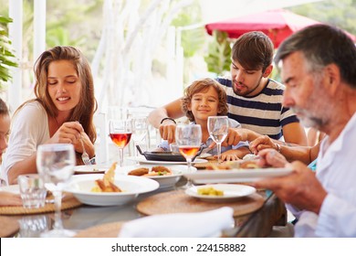 Multi Generation Family Enjoying Meal In Restaurant